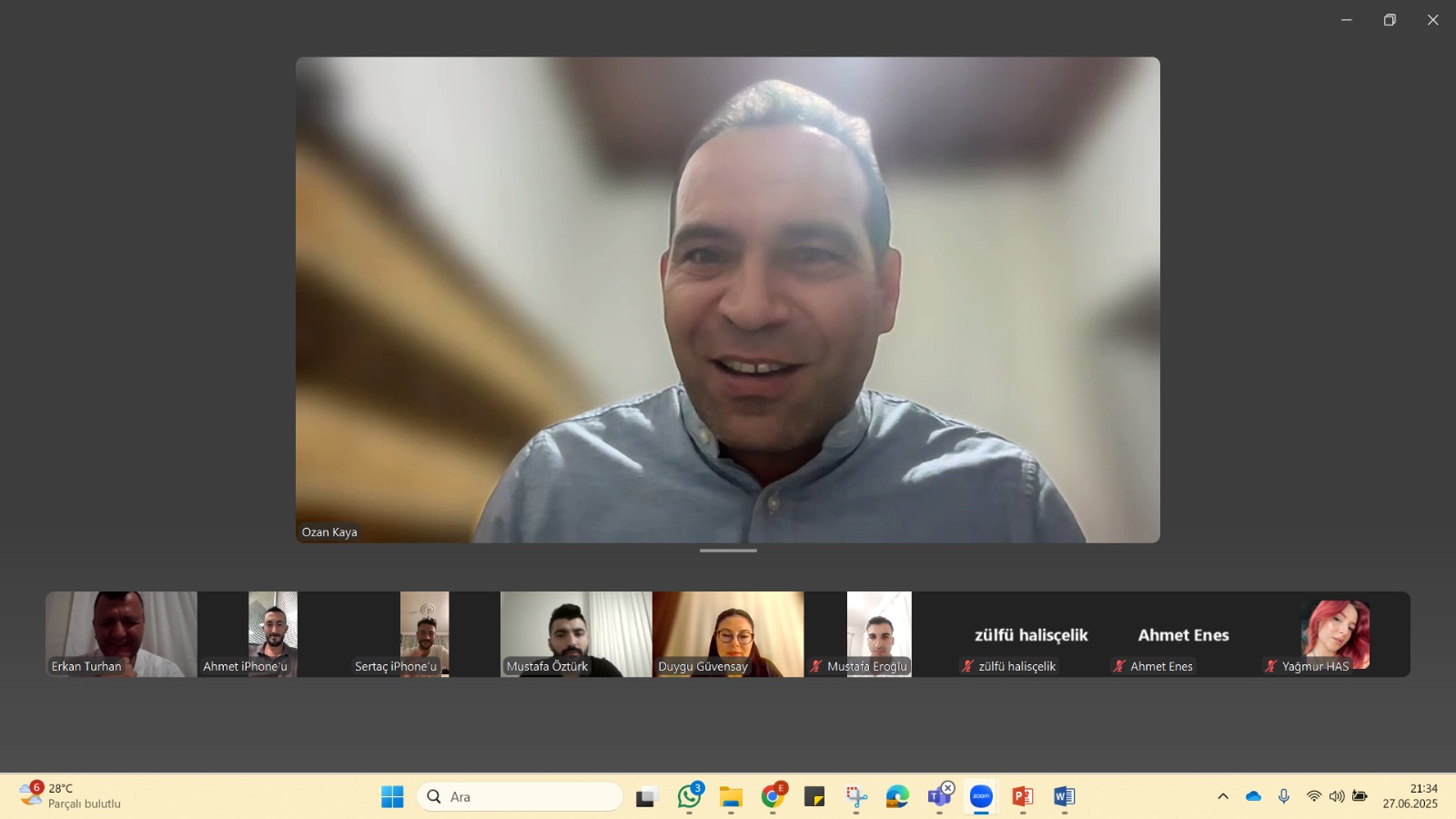 A screenshot from an online Zoom meeting. The main speaker shown on the screen is Assoc. Prof. Dr. Ozan Kaya, the School Director. Below, participant thumbnails are visible: Erkan Turhan, Ahmet, Sertaç, Mustafa Öztürk, Duygu Güvensay, Mustafa Eroğlu, Zülfü Halişçelik, Ahmet Enes, and Yağmur HAS. The time on the screen is 21:34, and the Zoom application is active on the taskbar.
